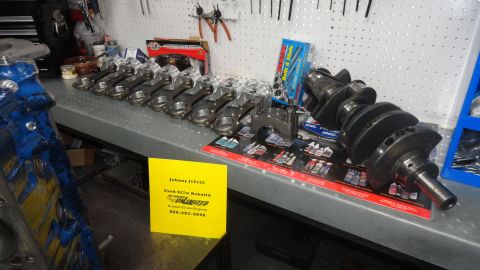 1982 Ford Bronco - Engine components, including a crankshaft and connecting rods, are displayed on a workbench, possibly for a Ford 427 rebuild.