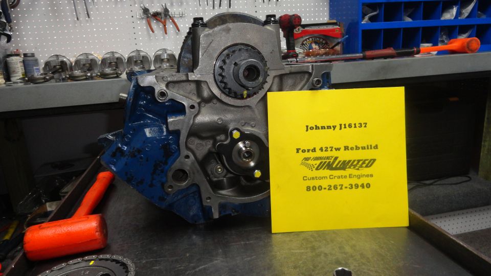 Ford 427w engine block with yellow sign detailing "Ford 427w Rebuild" and "Custom Crate Engines"