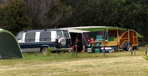 1969 Lincoln Continental - Van and teardrop trailer set up for camping in a grassy area with trees in the background.