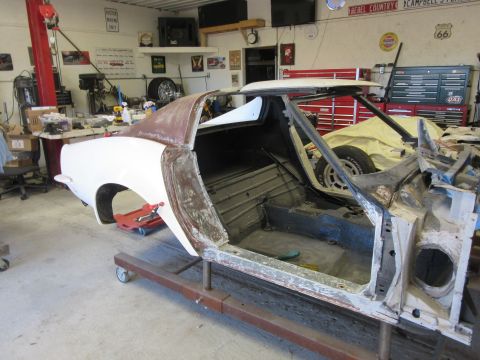 1976 Chevrolet Corvette - A car body is being worked on in a garage, with tools and equipment visible in the background.