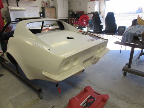1976 Chevrolet Corvette - The rear section of a white 1976 Chevrolet Corvette is shown in a garage, possibly undergoing restoration.