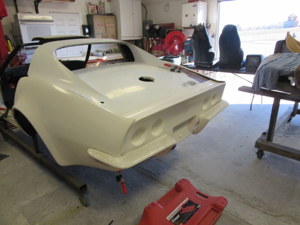 White 1976 Chevrolet Corvette body, rear view, in garage