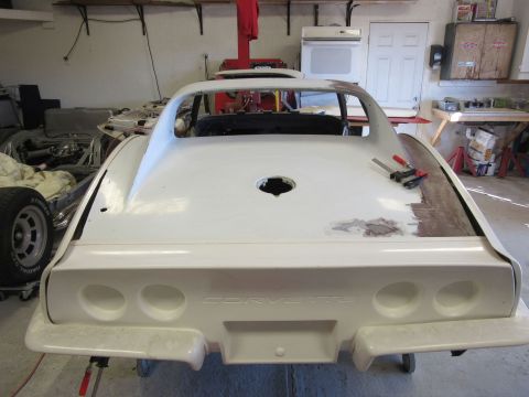 1976 Chevrolet Corvette - Rear view of a 1976 Chevrolet Corvette undergoing body repairs in a garage setting.