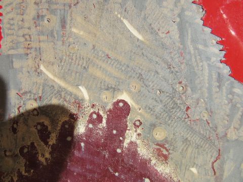 1976 Chevrolet Corvette - This image shows damaged metal with a textured surface and circular indentations, possibly from a vehicle part.