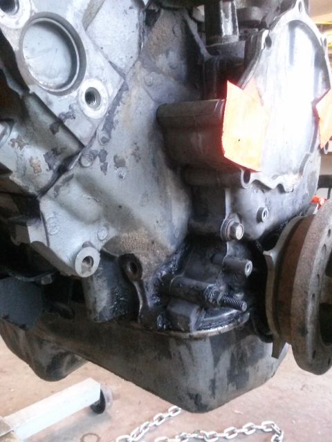 1996 Ford Bronco - Close-up view of an engine block and oil pan, possibly undergoing maintenance or repair.