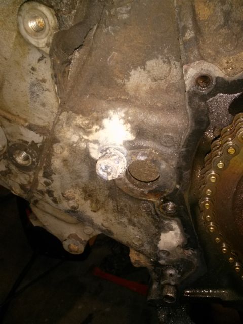 1996 Ford Bronco - This image shows a close-up of an engine block with a timing chain and various bolts, indicating mechanical work.