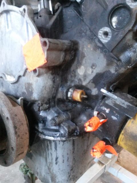 1996 Ford Bronco - Close-up of an engine block showing an oil sensor and orange tape, with the SuperMotors logo at the bottom.
