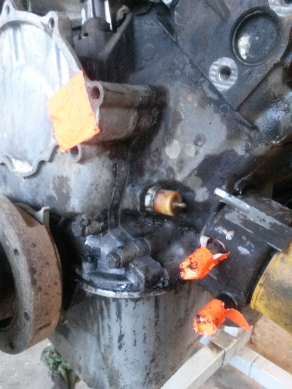 Engine block with oil sensor and orange tape, SuperMotors logo visible