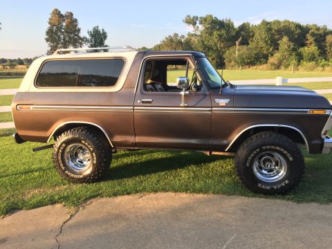 1978 Ford Bronco - Side profile of a brown 1978 Ford Bronco with a white top and roof rack.