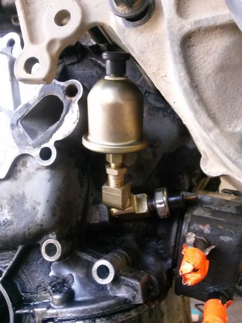 1996 Ford Bronco - Close-up of an engine oil pressure sensor and its brass adapter fitting.