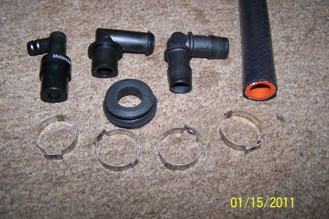 1996 Ford Bronco - Collection of automotive vacuum fittings, hose, and clamps laid out on a carpeted surface.