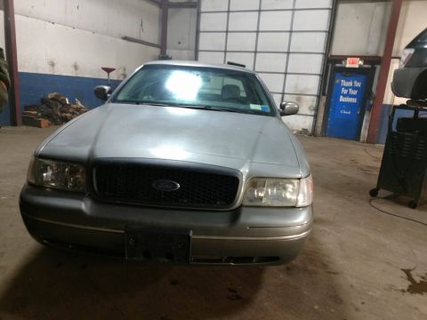 2003 Ford Crown Victoria - Front view of a silver 2003 Ford Crown Victoria parked indoors.
