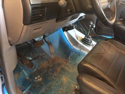 1995 Ford Bronco - The interior of a 1995 Ford Bronco reveals a manual transmission and worn flooring.