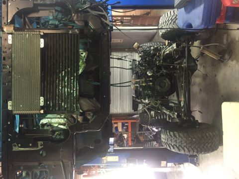 1995 Ford Bronco - Engine and radiator assembly on a lift, with large off-road tires.