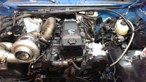 1995 Ford Bronco - The engine bay shows a Cummins 6.7L turbo diesel engine with a prominent turbocharger and intercooler piping.