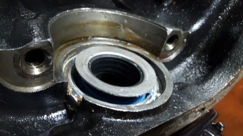 1994 Ford Bronco - A close-up view shows a metal component with a blue seal and a silver ring, likely part of an engine or drivetrain assembly. The surroundin…