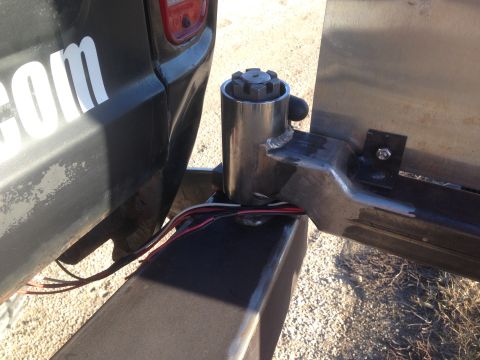 1979 Ford Bronco - A close-up view of the rear passenger side of a black Ford Bronco, showing a custom trailer hitch mount with wiring. The vehicle has a part…