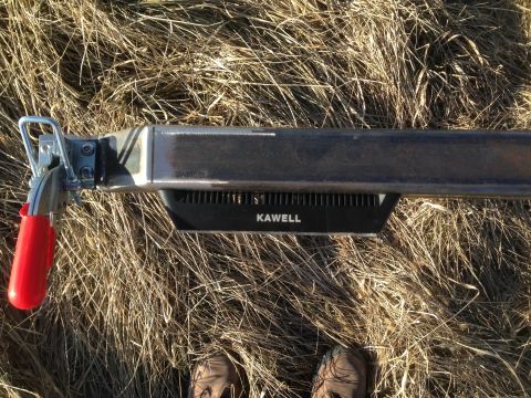 1979 Ford Bronco - A close-up view of a metal bar with a black attachment labeled "KAWELL" is mounted on it, with a red handle clamp on the left. The bar is p…