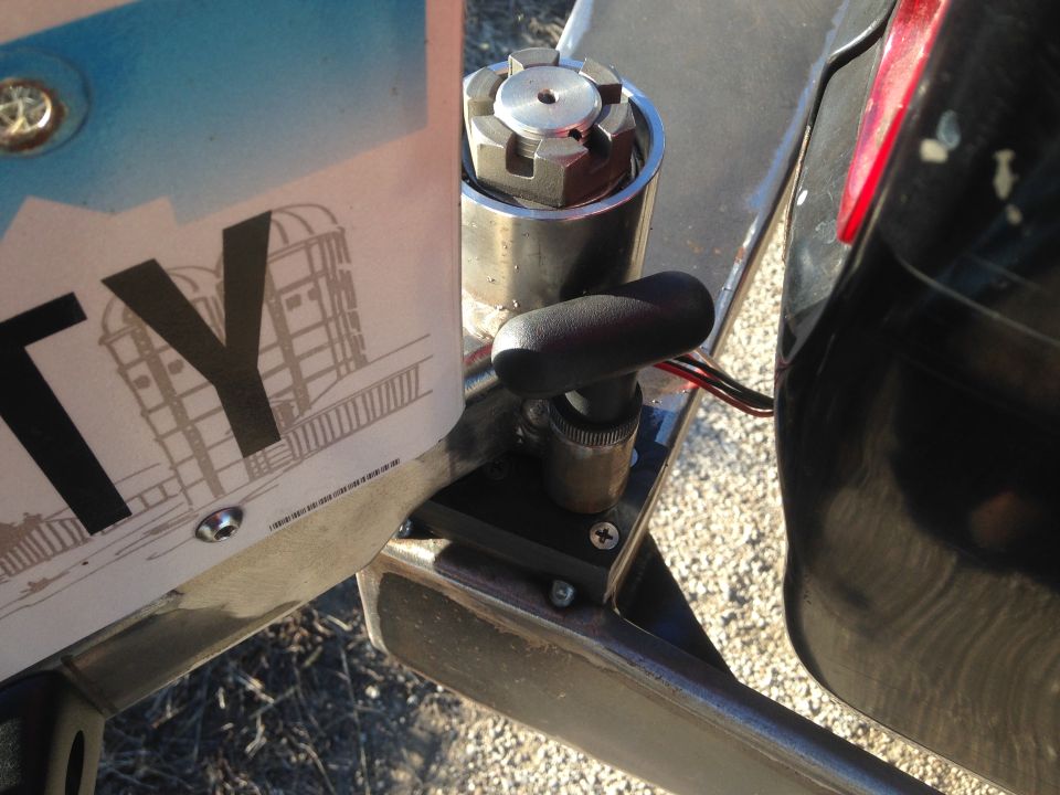 License plate with "TY" and building graphic, attached to a vehicle with a black lever.
