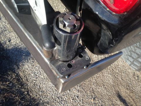 1979 Ford Bronco - A close-up view of a custom steel rear bumper on a vehicle, featuring a mounted mechanism with a large nut and bolts. The bumper is attache…