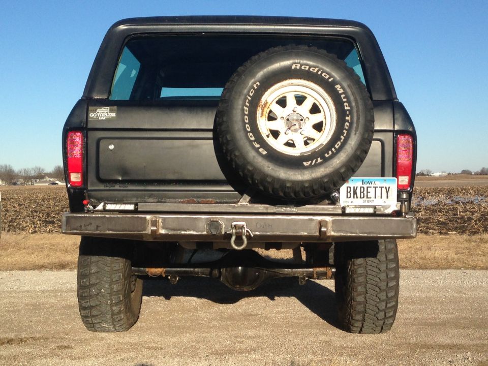 Rear view of a black Ford Bronco with a spare tire, custom bumper, and Iowa license plate.