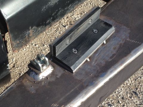 1979 Ford Bronco - A close-up view shows a black L-shaped bracket with two screws attached to a weathered metal surface. A small silver metal bracket with two…