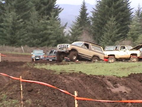 1994 Ford Explorer - Multiple off-road vehicles are seen on a muddy terrain during an event.