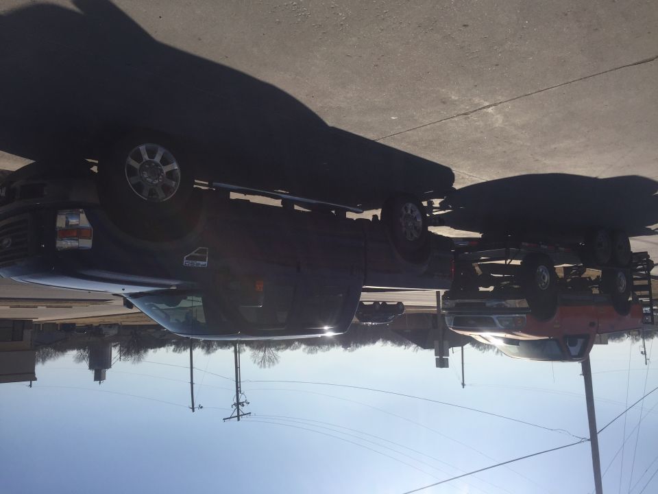 Dark blue Ford F-Series truck towing a red boat trailer.