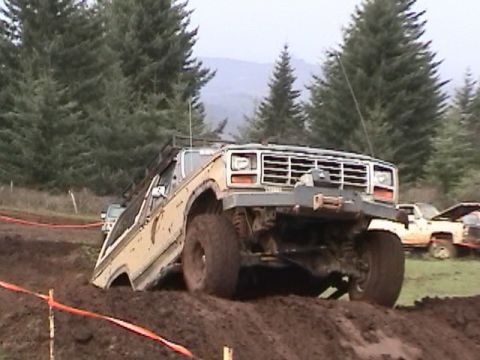 1994 Ford Explorer - This truck appears to be from the 1980s, not a 1994 Ford Explorer, as it navigates a muddy off-road course.