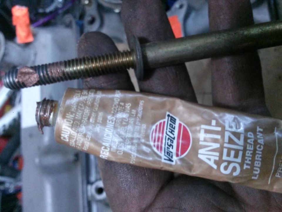 Bolt coated in anti-seize compound with a tube of anti-seize lubricant.