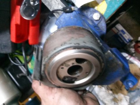 1996 Ford Bronco - A close-up, low-angle shot shows a person's hand holding a metal part, possibly a filter or housing, which is secured in a blue vise. The p…