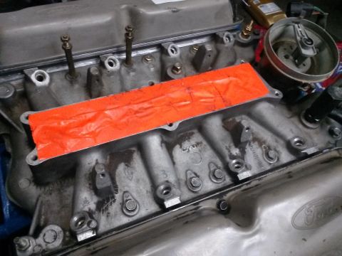 1996 Ford Bronco - A close-up view of a Ford engine's intake manifold, covered with orange tape. The engine appears to be from a 1996 Ford Bronco, as indicate…