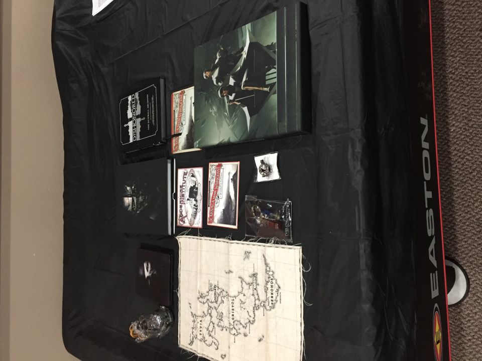 Collection of video games, books, and a map on a black tablecloth.