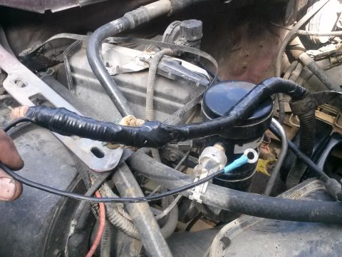 1996 Ford Bronco - A close-up view of engine wiring, showing black electrical tape wrapped around a section of wires and a blue ring terminal connected to a s…