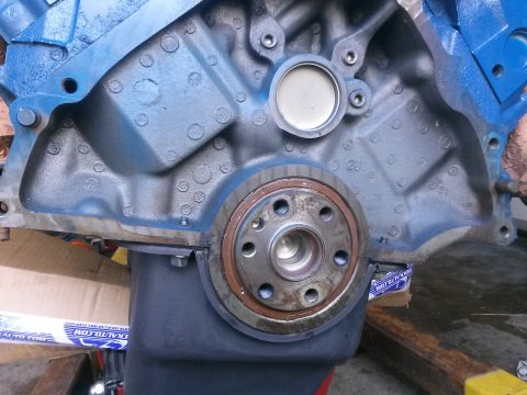 1996 Ford Bronco - A close-up view of the rear of a blue engine block, showing the crankshaft seal and oil pan.