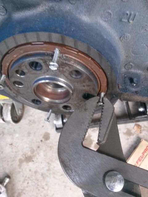 1996 Ford Bronco - A close-up shot shows a mechanic using channel lock pliers to grip a screw near a rusty seal on what appears to be a vehicle's engine block…