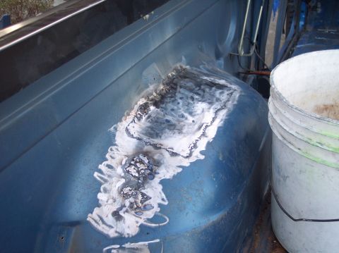 1990 Ford Bronco - Welding repair on the interior wheel well of a blue vehicle.