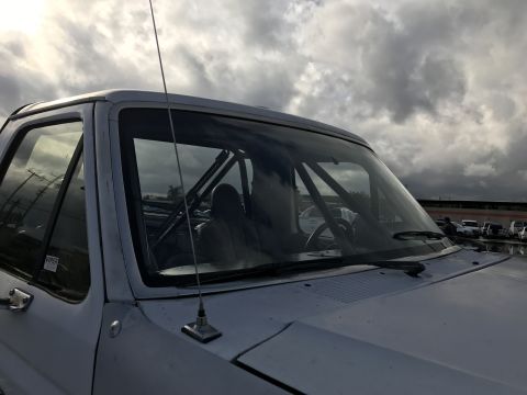 1990 Ford Bronco - Photo of a pickup truck windshield showing an interior roll cage, not a technical document.