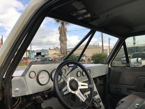 1990 Ford Bronco - Photo of a truck interior with aluminum dash and racing steering wheel, not a technical document.