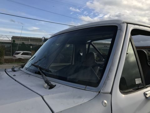1990 Ford Bronco - Photo of a pickup windshield showing roll cage and racing seat, not a technical document.