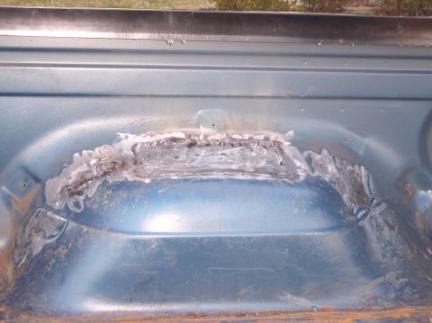 1990 Ford Bronco - Close-up of a welded patch on the blue metal interior of a vehicle bed, indicating body work.