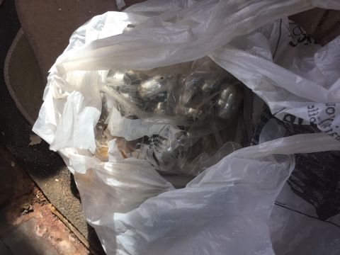 1979 Ford Bronco - A plastic bag holds numerous metal parts, possibly related to vehicle maintenance or repair.