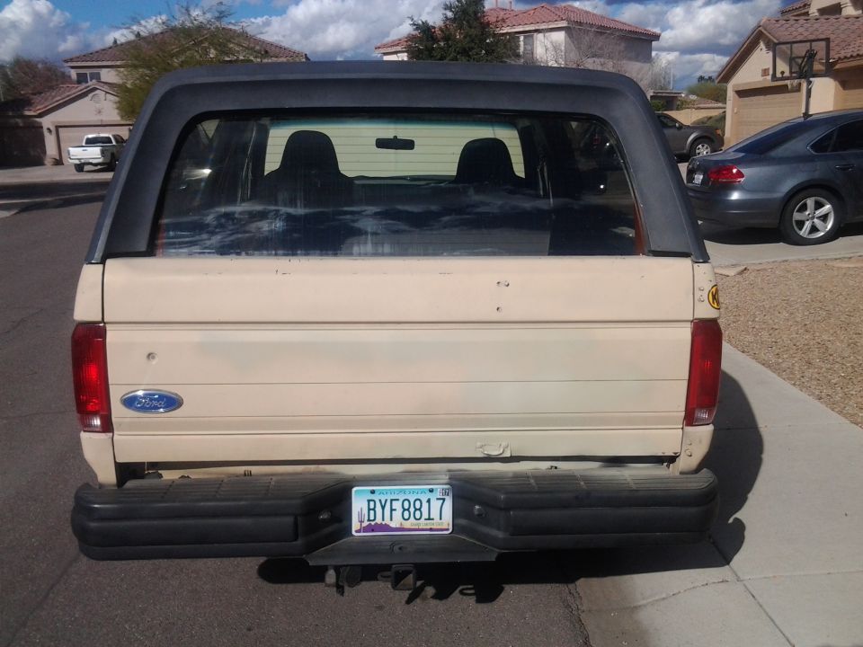 Tan 1992 Ford Bronco rear view with black bumper and tinted windows