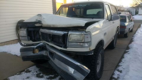 1995 Ford Bronco - This white SUV has significant damage to its front end after an apparent collision.