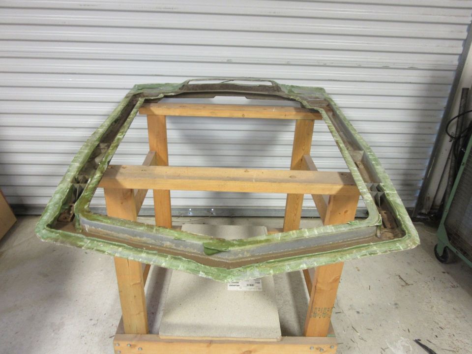 Windshield frame assembly, green fiberglass, on wooden sawhorses