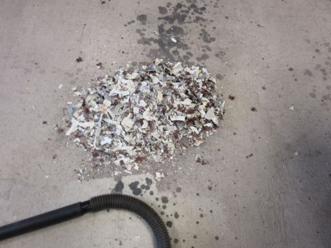 1976 Chevrolet Corvette - Debris and a vacuum hose are on a stained concrete floor.