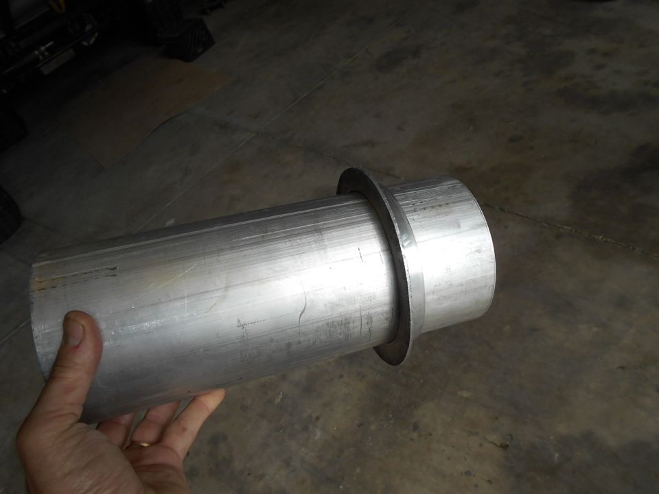 Silver metal exhaust pipe with flared end held by a hand