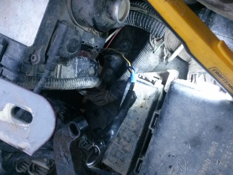 1996 Ford Bronco - A close-up view of a vehicle's engine bay, focusing on a fuse box and wiring harness. A yellow Craftsman work light is visible, illuminatin…
