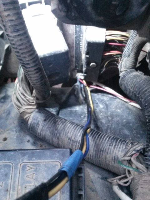 1996 Ford Bronco - A close-up view of a bundle of automotive wires, some of which are taped with blue electrical tape, connected to a black electrical compone…