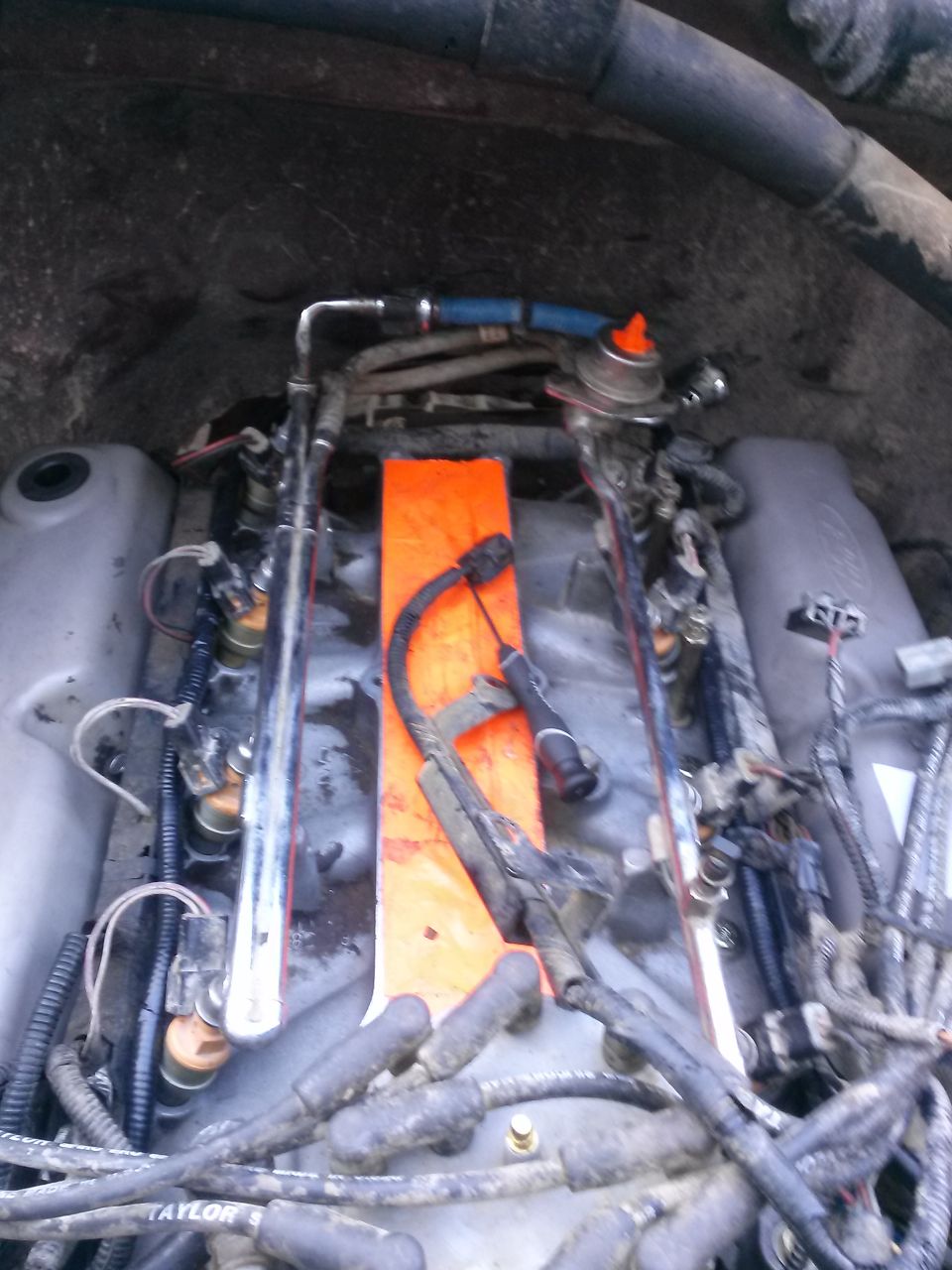 1996 Ford Bronco engine bay with fuel injectors and spark plug wires visible.